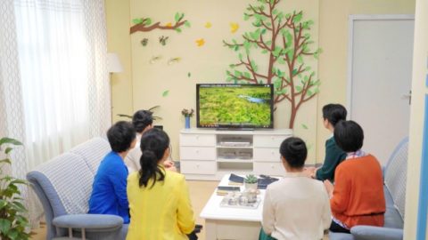 幾個弟兄姊妹在室內看福音視頻